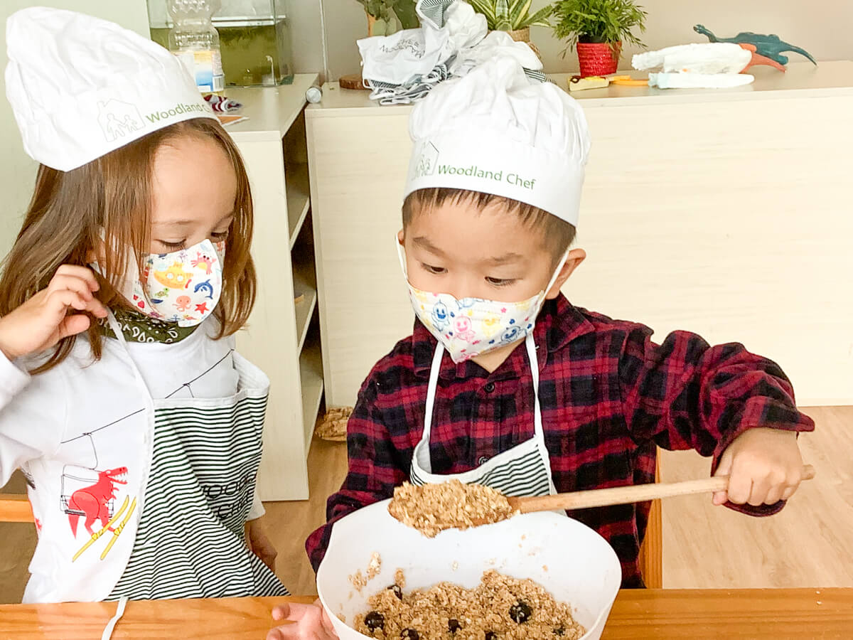 two young children cooking together 